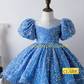 A blue sequined girls' dress displayed on a mannequin torso against a light gray wall. The dress has puff sleeves, a square neckline, and a full skirt covered in reflective sequins.
House of Claire Celeste Sparkle Blue Luxury Ball Gown for Girls with Puff Sleeves – Premium Birthday & Party Dress in Bangalore online india
www.houseofclaire.com